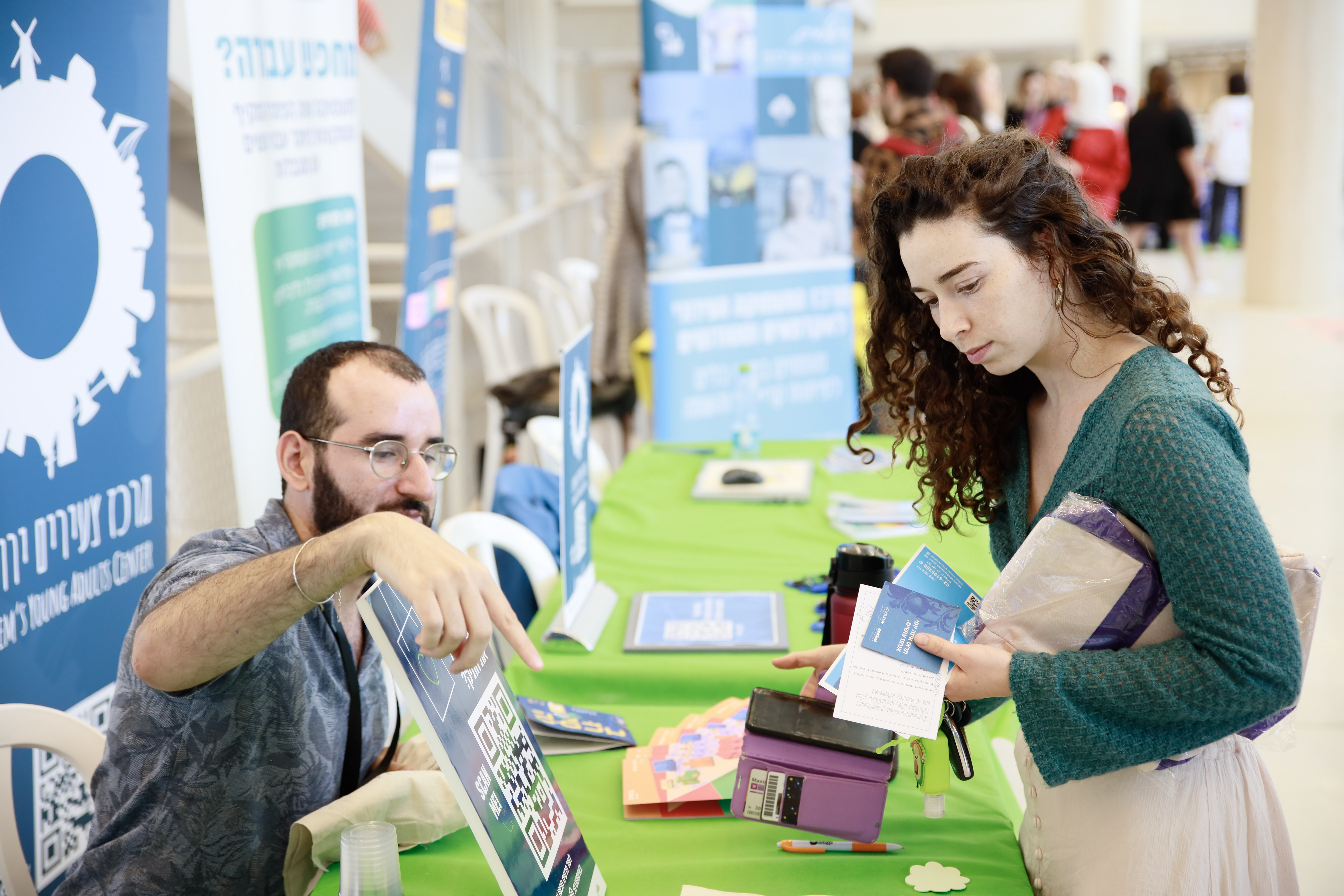 סטודנטים וסטודנטיות מנהלים שיחה בדוכן תעסוקה