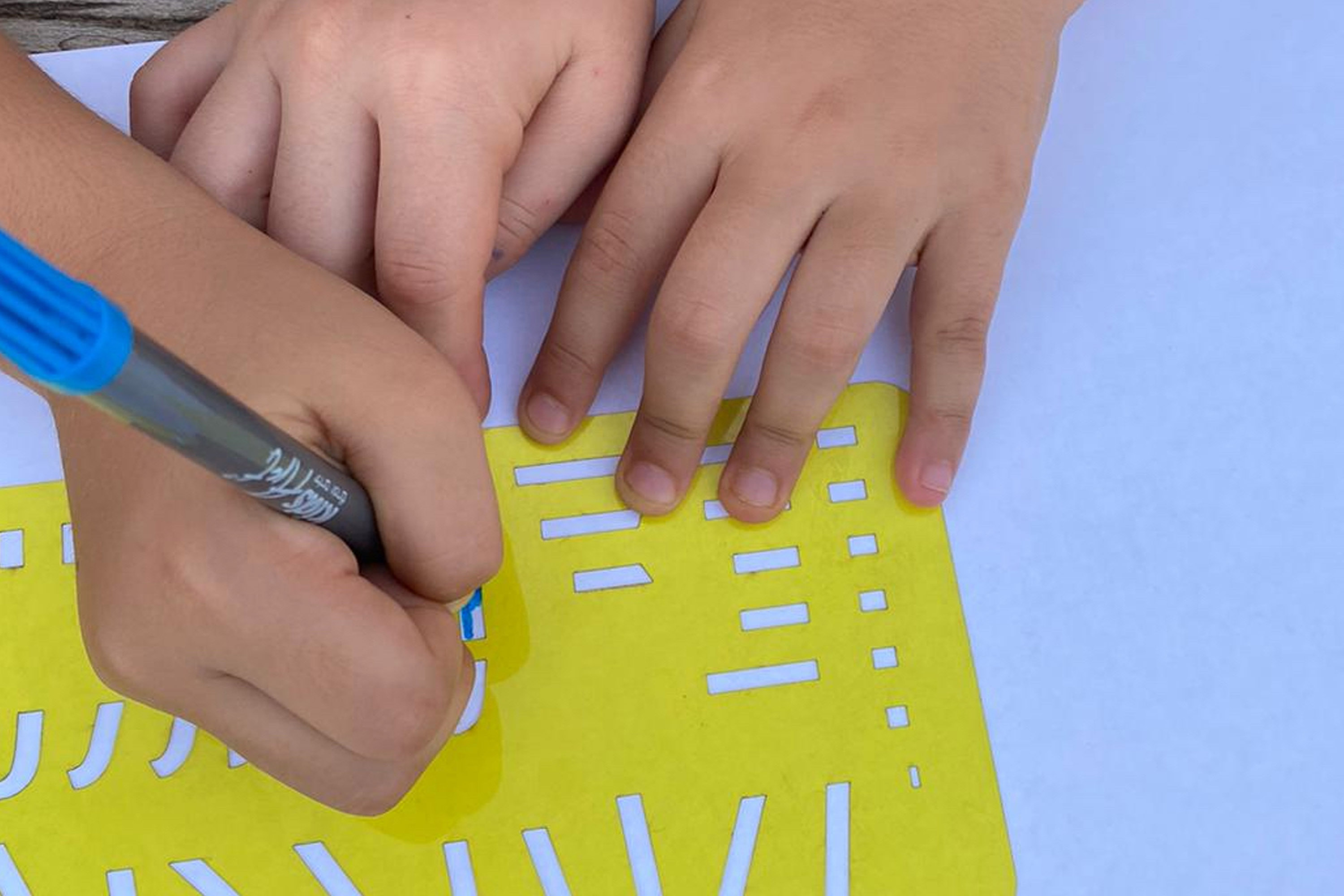 ידיים של ילדים משתמשים בשבלונות מתוך הספר