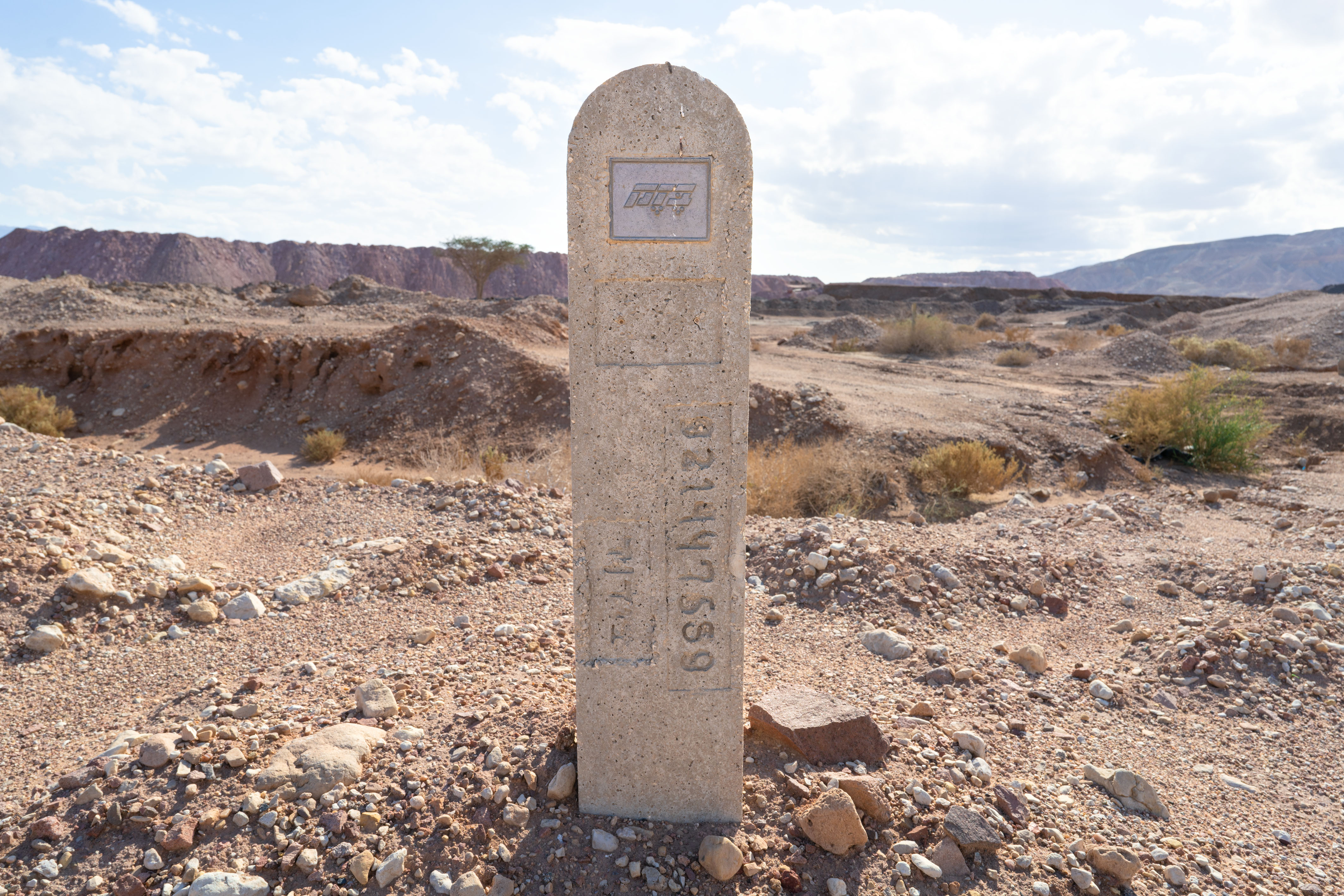 Gravestone with Bezeq Sign logo in the desert