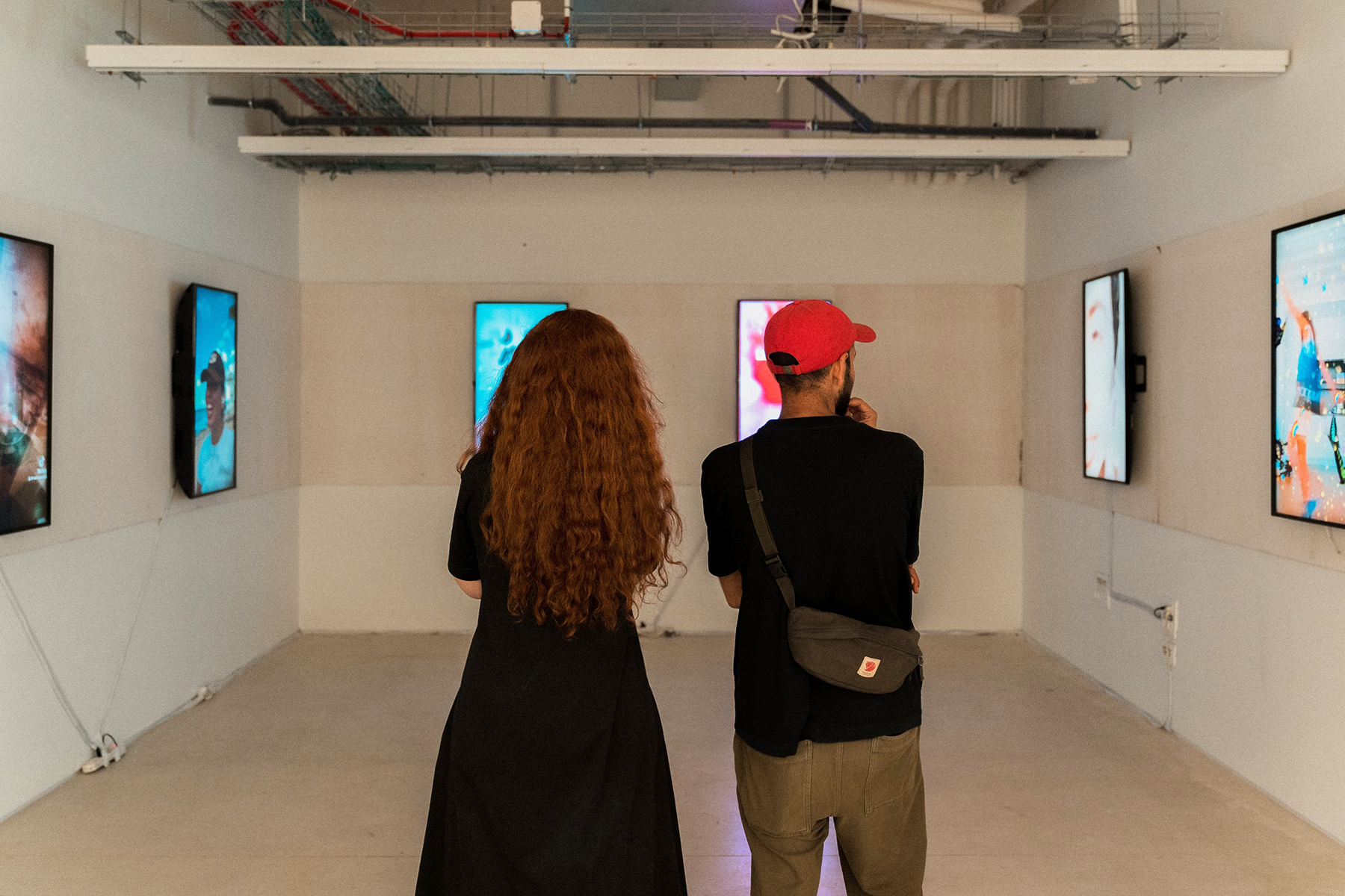 2 אנשים עומדים בחדר מול מסכים