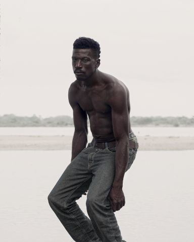 גבר עם מכנס ג׳ינס, ללא חולצה, עומד ומיישר מבט למצלמה, צילום של Felipe Romero Beltran
