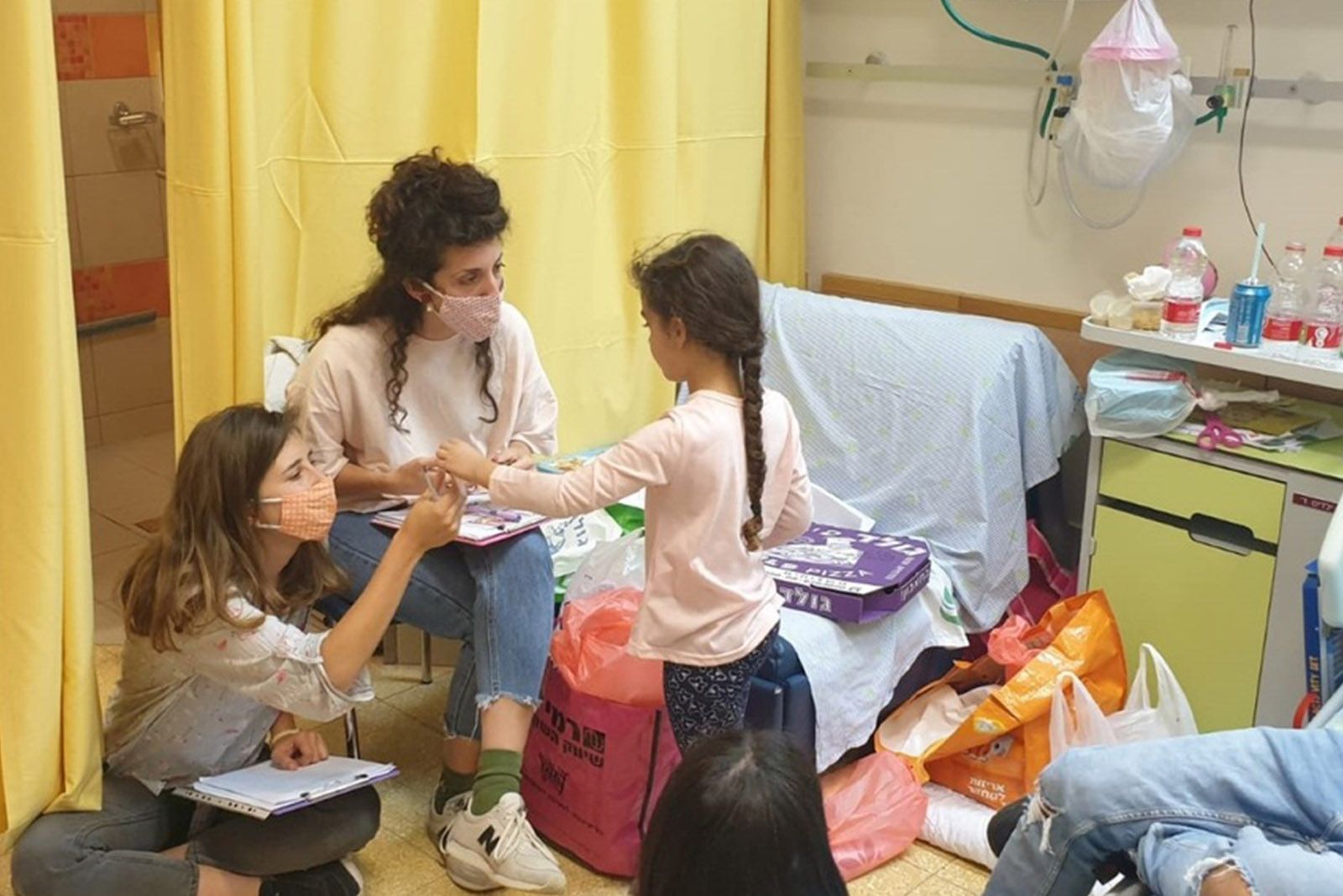 סטודנטיות בפרויקט פלורנס בבי"ח סורוקה עובדות עם ילדה ממחלקת ילדים