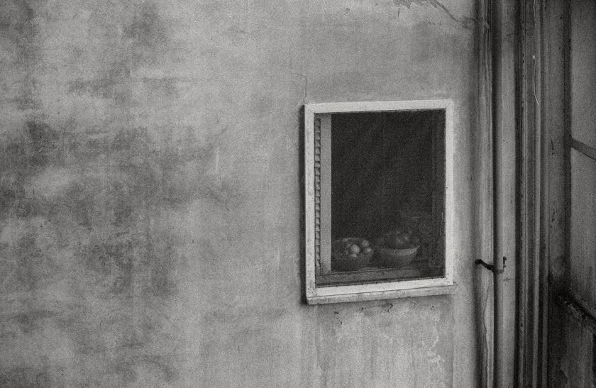 ציור שחור לבן, קיר חיצוני של בית ועל החלון קערה עם פירות