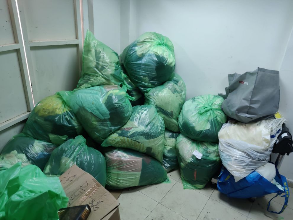 תמונה של חדר עם שקיות אשפה מלאות בביגוד