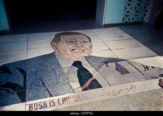 הכיתוב BUSH  IS CRIMINAL עם איור קריקטורה על גבי המרצפות